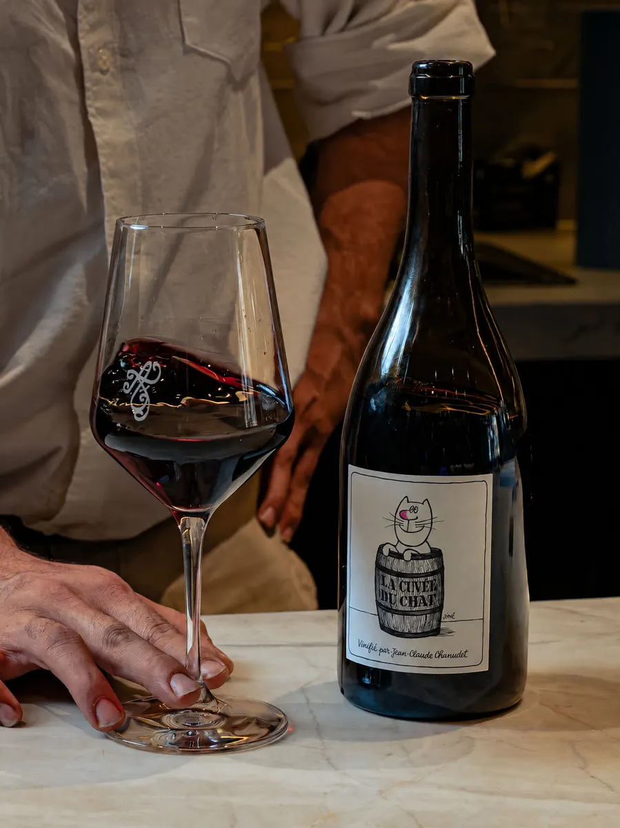 A glass of red wine poured at the counter