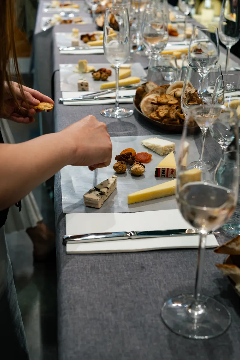 A guest picking up a piece of cheese